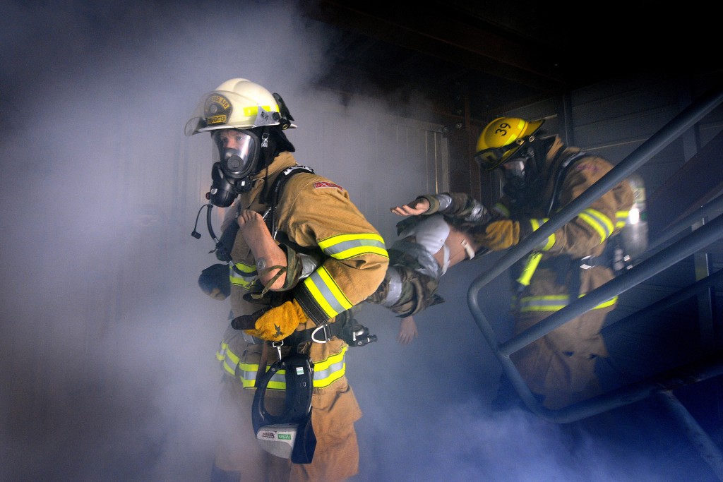 101203-F-2319R-915 Commander of the 50th Space Wing Col. Wayne Monteith and firefighter Cody Marion join together to rescue a simulated victim from a smoke-filled room in the fire suppression training facility at Schriever Air Force Base, Colo., on Dec. 3, 2010. The commander participated in the training to get firsthand experience. DoD photo by Dennis Rogers, U.S. Air Force. (Released)
