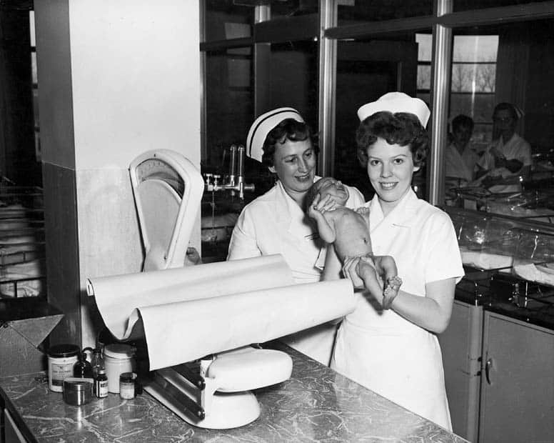 Two_nurses_with_baby_in_nursery_at_Toronto_East_General_and_Orthopaedic_Hospital,_Toronto,_ON