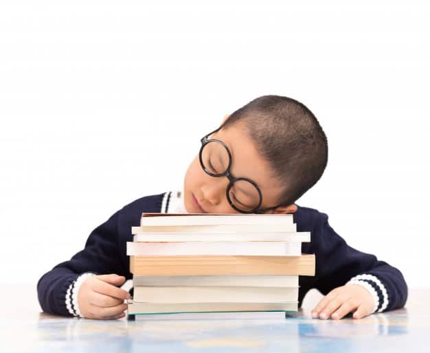 schoolboy-sleeping-on-school-books_1127-328