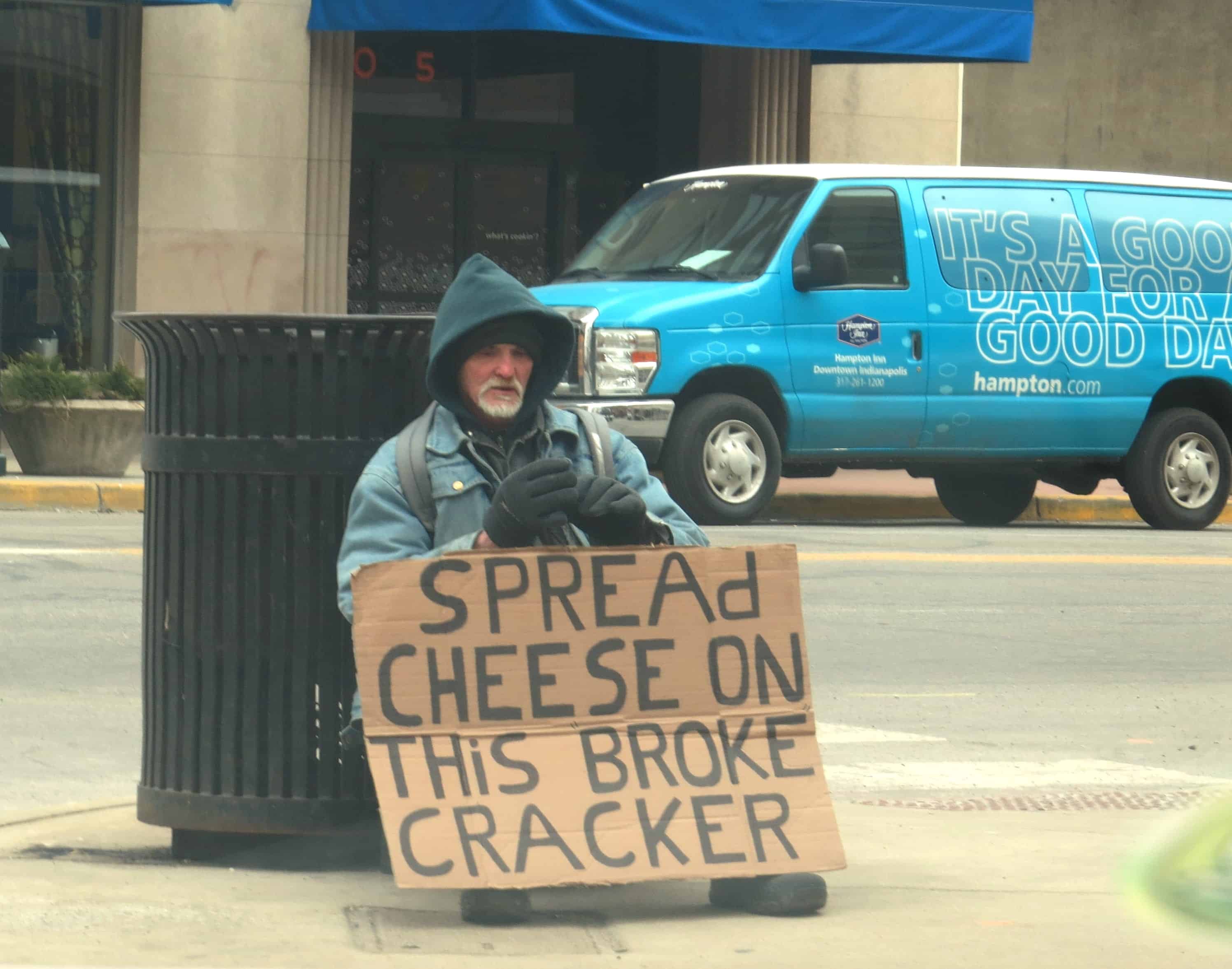 Hajléktalan táblával "Spread cheese on this broke cracker"